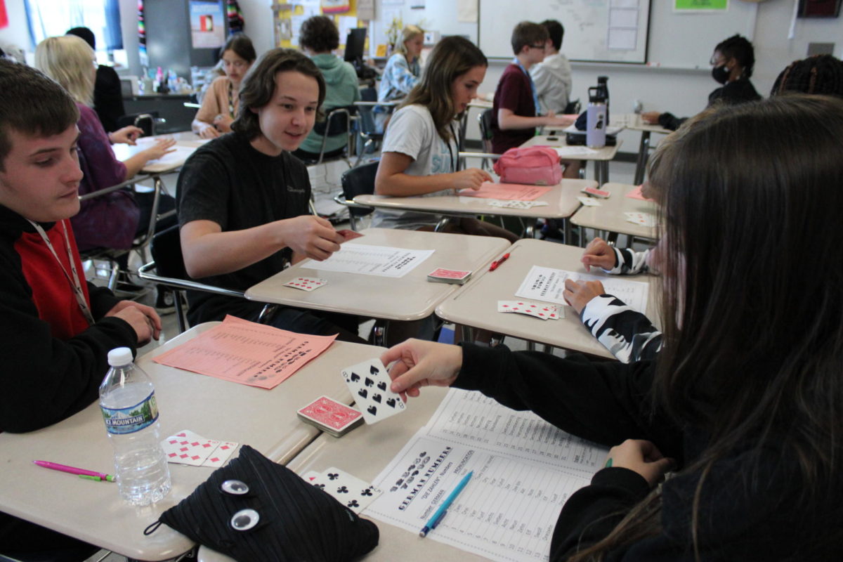 Students of 8th hour World Language and Culture class play a card game. In this game students are in partners and will be split a deck of cards. Then they will each draw one card and whoever says the sum of the two cards in German first, wins. 