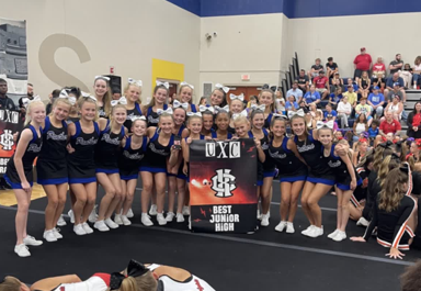 On the last day of camp, Liberty Cheerleaders pose with the “Best Junior High” poster they won.